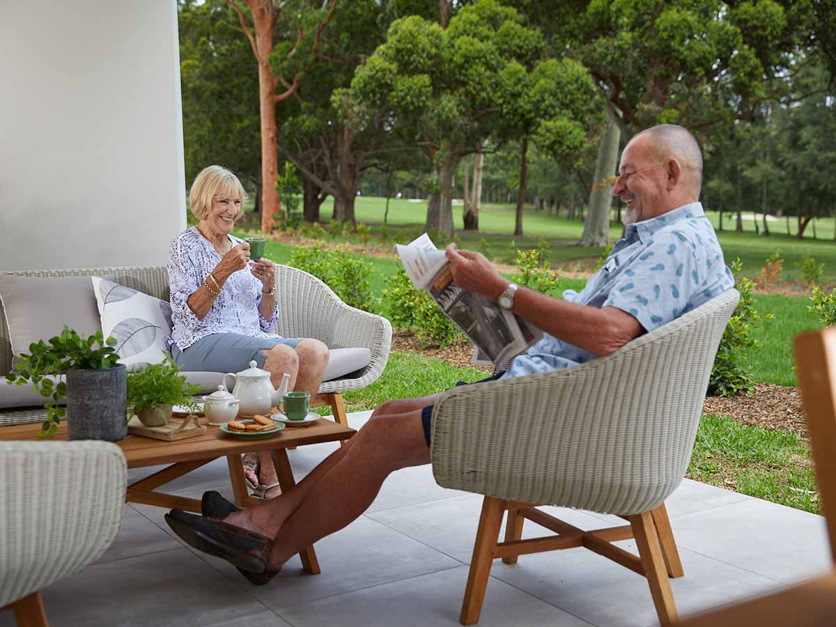 aveo newcastle retirement residents sitting on patio reading newspaper