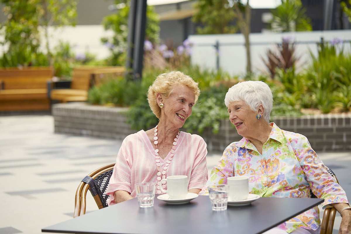 Two Ladies Catching Up Over Coffee Outdoors